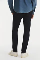 Pantalón de jean de hombre, color azul oscuro (rinse), con calce ajustado en cadera y muslos, pierna súper ajustada y tiro medio.