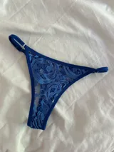 Bombacha de encaje azul con tiras regulables en los costados.