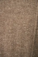 Chaqueta corta color beige, entallada, con escote en V, manga larga y bolsillos escondidos. Cierre frontal con lazo fijo. Confeccionada en lana fina sin teñir. Diseño exclusivo de Don Baez.