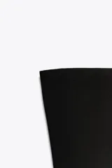 Body bandeau de tejido elástico, con escote recto y diseño sin hombros. Cuenta con cierre inferior mediante botones a presión.