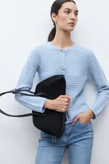 Chaqueta de punto color celeste, con cuello redondo, manga larga y cierre frontal con botones metálicos plateados.