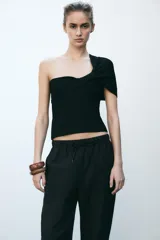 Pantalón tobillero color beige, con cintura elástica ajustable con cordones, bolsillos delanteros y falsos bolsillos con solapa en la espalda.