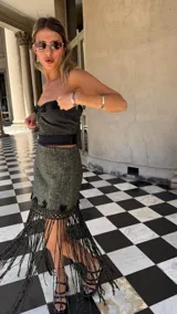 Falda asimétrica de tejido lurex negro y dorado, con pretina elástica y apliques de crochet en el ruedo.