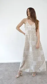 Vestido largo de tirantes finos con estampado de hojas en tonos beige y blanco.