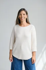 Sweter de punto color crudo, con escote a la base y mangas tres cuartos con dobladillo.