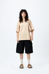 Remera blanca de corte amplio con mangas cortas y estampado con la frase "Unlearn" en el frente y gráfico en la espalda.