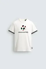 Camiseta de corte relajado confeccionada en piqué de algodón color crudo. Presenta cuello redondo, mangas cortas con ribetes a contraste y estampado frontal con el logo de Italia 90 FIFA World Cup.