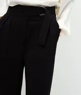 Pantalón de corte wide leg confeccionado en crepé color bordó, con cintura alta, cierre frontal con cremallera y detalle de hebilla ajustable en la cintura.