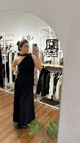 Vestido largo de fiesta color azul oscuro con acabado brillante, diseño de un solo hombro con detalle de cuello tipo choker y falda amplia con caída fluida.