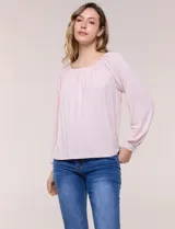 Blusa de modal y elastano color blanco, de silueta holgada, escote redondo amplio con elástico interno fruncido y mangas largas fluidas con puños ajustados.