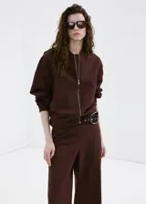 Pantalón marrón de corte recto y tiro medio, confeccionado en mezcla de lino, viscosa y algodón. Cuenta con diseño largo y cintura elástica.