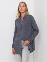 Camisa de corte largo y holgado, con estampado de rayas verticales en azul marino y blanco. Presenta cuello con solapa, cierre frontal con botones, bolsillo en el pecho y mangas largas con puños abotonados.