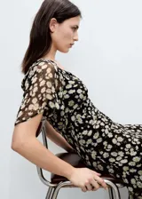Vestido midi de gasa con estampado floral, cuello en pico y mangas cortas. Presenta un diseño recto, cierre de cremallera lateral y forro interior.