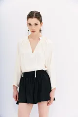 Short negro de corte holgado con cintura elástica y cordón ajustable. Presenta un diseño fluido y ligero.
