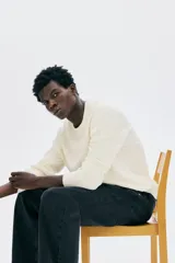 Buzo de algodón fino color crema, con cuello redondo y manga larga. Presenta un tejido de punto acanalado vertical y un bajo recto.