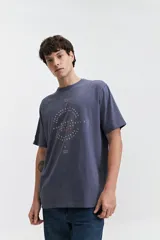 Remera de manga corta color marrón, con ajuste regular y escote redondo. Presenta un estampado frontal con texto en blanco formando un diseño circular.