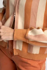 Cárdigan tejido con cierre frontal, diseño a rayas horizontales en tonos naranja, beige y rosa, cuello tipo polo y mangas abullonadas.