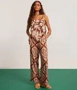 Pantalón pantalona con cintura alta, cintura ancha con botones forrados en los laterales y estampa tropical estilo pañuelo con flores.