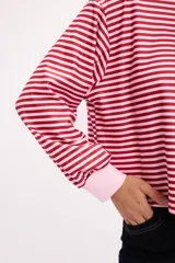 Remera de manga larga con diseño a rayas horizontales en color rojo y rosa, cuello redondo y puños elásticos.