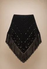 Ruana tejida en lana merino, diseño artesanal con calados delicados y terminación con flecos largos en todo el borde. Presenta una caída suave y envolvente.