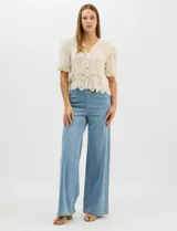 Jegging de tiro alto con silueta estilo palazzo y pierna amplia. Confeccionado en tejido denim con pretina ancha elástica, sin cierre frontal. Presenta diseño frontal liso sin bolsillos y dos bolsillos traseros tipo parche.