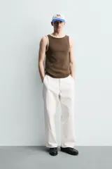 Camiseta sin mangas slim fit color crema, confeccionada en tejido de algodón elástico, con cuello redondo y ribetes en contraste color beige.
