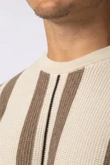 Remera de tejido de punto con diseño de rayas verticales en tonos beige y marrón, de manga corta y cuello redondo.
