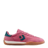 Championes Converse Run Star Trainer, color rosado con detalles en verde oscuro. Presentan una combinación de gamuza y material textil, con el logo de la estrella y la flecha característico en el lateral, entresuela blanca y suela de goma color caramelo.