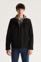 Campera militar negra con capucha gris de algodón, cierre frontal con cremallera y botones a presión, cuatro bolsillos frontales con solapa y charreteras en los hombros.