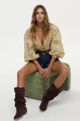 Blusa estampada con diseño paisley en tonos beige y amarillo, con mangas abullonadas de tres cuartos y escote en V profundo.