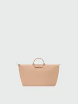 Bolso de viaje de gran tamaño, modelo Le Pliage One de Longchamp, en color marrón. Presenta el diseño icónico de la marca con solapa de cuero, asas cortas y cierre de cremallera superior.