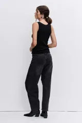 Blusa de punto sin mangas, color negro, con escote redondo y detalle de pequeñas tachas metálicas plateadas distribuidas por toda la prenda.