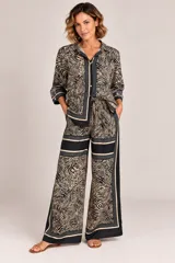 Camisa de satén con estampado animal print tipo cebra en tonos camel y negro, con cuello camisero, botonadura frontal y puños anchos con ribetes.