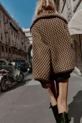 Chaqueta de punto con estructura, corte oversize, cuello solapa, manga larga, bolsillos delanteros y cierre frontal con botones.