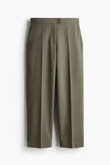 Pantalón cigarette tobillero color verde militar, con cintura estándar, cierre y pretina prolongada con corchete oculto. Presenta piernas ajustadas con abertura corta en los bajos, bolsillos al bies y un bolsillo decorativo en la parte trasera. Incluye pliegues en la parte delantera y trasera.