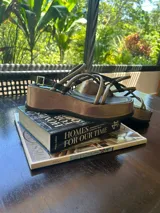 Sandalias marrones de plataforma con tiras finas cruzadas y hebilla ajustable en el tobillo.