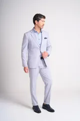 Ambo de dos piezas color gris claro, compuesto por un saco de corte clásico con solapas de muesca y un pantalón de vestir de corte recto con dobladillo en el ruedo.