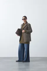 Blazer de corte relajado con estampado de cuadros tipo pied de poule en tonos rojizos y verdes. Presenta solapas clásicas en color azul oscuro y estructura definida.
