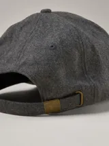 Gorra de béisbol de paño en color azul marino, con etiqueta lateral con logo de la marca.