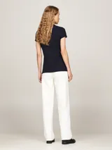 Chomba Tommy Hilfiger azul marino de piqué de algodón elástico, corte slim, cuello de chomba, cartera de cuatro botones y logo bordado en el pecho y en la manga.