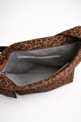 Bolso tipo hobo con estampado animal print y acabado efecto gamuza. Cuenta con asa regulable y cierre superior con cremallera.