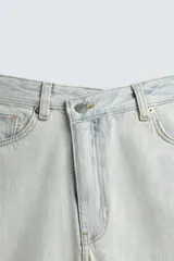 Jeans de mezclilla, tiro medio, color celeste claro lavado con efecto desgastado y roturas pronunciadas en ambas piernas. Corte ancho y relajado.