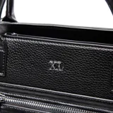 Cartera de mano tipo tote marca XL, color negro, confeccionada en material símil cuero con textura granulada. Presenta doble asa superior, correa ajustable y extraíble, y un bolsillo frontal con cierre metálico.