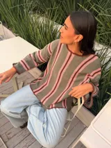 Sweater de tejido de punto de algodón con diseño rayado en color blanco, bordó y rosado, cuello redondo a la base, mangas largas acampanadas y silueta oversize.