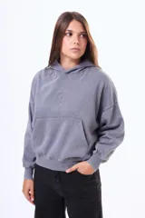 Buzo tipo canguro de felpa con efecto lavado, color violeta, con capucha, bolsillo frontal tipo canguro y mangas largas con puños ajustados.