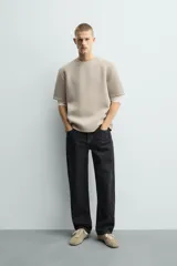 Sudadera de manga corta con corte relajado, confeccionada en tejido técnico compacto de algodón con elasticidad. Presenta cuello redondo y detalle de tacha metálica en la espalda.