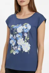 Remera de algodón blanca de manga corta, con cuello redondo y estampado frontal con la leyenda "New York" y flores abstractas en tonos marrones y rosados.