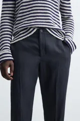 Pantalón de vestir azul marino confeccionado en tejido de lino. Corte recto, con bolsillos laterales y traseros. Se ajusta a la cintura con botón y cremallera.