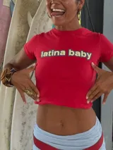 Remera corta roja con cuello redondo, manga corta y estampado frontal con la frase "latina baby" en azul.