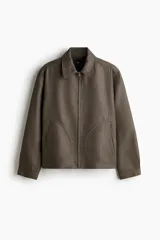 Campera con cuello, cierre oculto frontal, bolsillos insertados delanteros y bolsillo interior. Mangas largas con puños abotonados y trabilla ajustable con botón en los laterales del bajo.